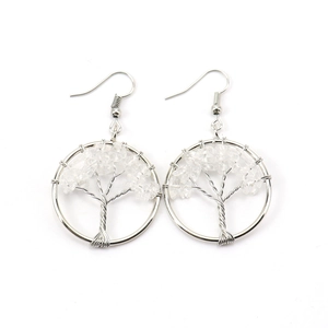 Detail of handmade silver tree of life earrings with clear crystal stones in a round frame