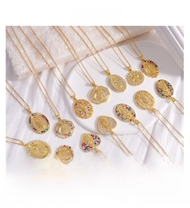 Detail of gold-plated Virgin Mary pendants with colorful cubic zirconia on silk