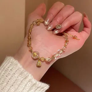 Elegant beaded bracelet with yellow citrine, white crystal, and a gold bell charm
