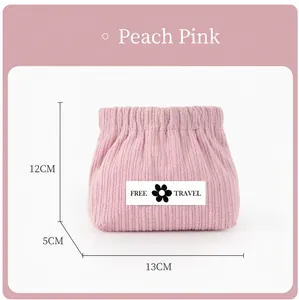 Close-up of pink corduroy lipstick pouch with FREE TRAVEL logo and snap closure