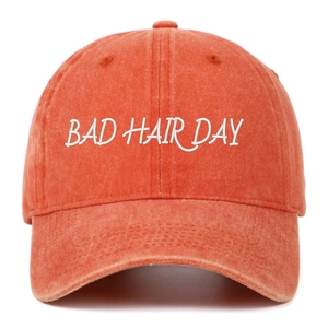 Détail de la broderie BAD HAIR DAY sur une casquette de baseball orange délavée