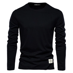 Detailed macro view of the knitted cotton fabric and round neckline of a black long-sleeve tee