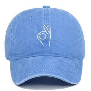 Close-up of OK hand gesture embroidery on washed blue denim baseball cap front