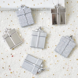 Silver Christmas gift box ornaments with glitter and shiny finish on white faux fur