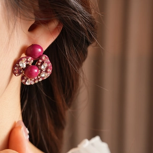 Macro detail of vintage magenta ball earrings with purple enamel and sparkling crystals