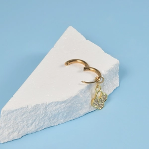 Gold stainless steel hoop earrings featuring a sparkling clover pendant with pavé crystals