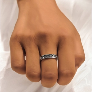 Detail of vintage S925 silver ring featuring moon and star reliefs with oxidized finish