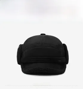 Detail of warm black winter trapper hat with soft fleece lining and metal sports logo