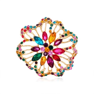 Macro shot of gold-plated floral brooch featuring intricate colorful rhinestone inlays