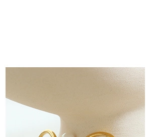Close-up of golden necklace featuring a white irregular baroque pearl pendant on mannequin