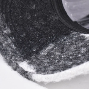 Close-up of classic plaid bouclé fabric texture on a warm baseball cap for winter