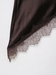 Gros plan sur un tissu en satin marron foncé avec bordure en dentelle délicate