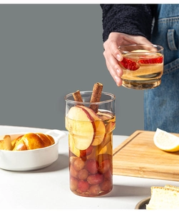 Detail of stacked heat-resistant glass cups featuring fruit and cinnamon-infused drinks