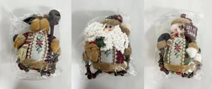 Detail view of plush Christmas dolls Santa, Snowman and Reindeer in protective packaging