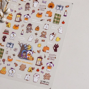 Detail of Halloween nail art stickers with cute pumpkin and ghost motifs on beige texture
