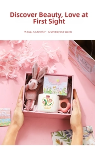 Close-up of pink tulip ceramic mug with flower handle and plush rabbit in gift box