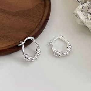 Elegant S925 sterling silver geometric twist hoop earrings on a vintage paper background