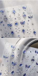 Close-up macro detail showing 3D embossed blue butterfly and moon nail art decals