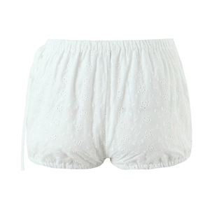 Detailed view of white cotton shorts with floral eyelet embroidery and scalloped edges
