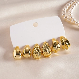 Gros plan d'un lot de 3 paires de boucles d'oreilles dorées avec gouttes et formes en C