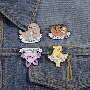 Cute animal enamel pins set featuring sloth and capybara designs on blue denim jacket