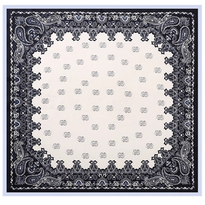Flat lay of square silk scarf with navy blue paisley border and cream geometric pattern