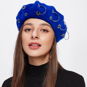 Close-up of blue wool beret featuring trendy silver metal rings and eyelet decorations