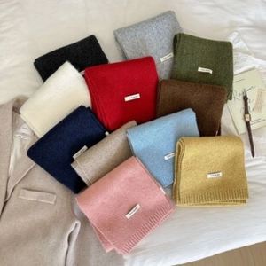 Flat lay of colorful cashmere-feel scarves with White Label tag and lifestyle items