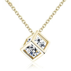 Close-up of golden geometric cube necklace with central sparkling cubic zirconia stone