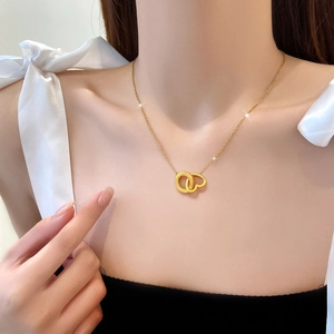Collana minimalista in titanio dorato con ciondolo a cuore e anello intrecciati da donna