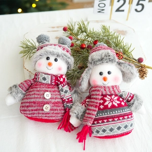 Detailed view of plush Christmas snowman figurines with knitted scarves and wooden buttons