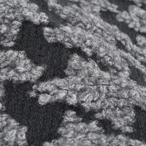 Close-up of thick bouclé knit beanie with black and grey jacquard pattern weave