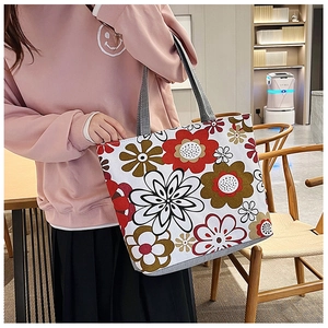 Detail of a floral canvas tote bag showing large vibrant prints and durable thick handles