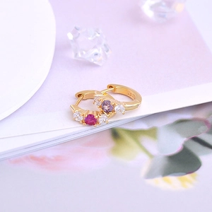 Detailed close-up of S925 silver gold-plated huggie earrings with red and purple zircons