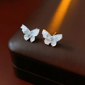 Detailed view of silver butterfly stud earrings with sparkling crystals in a display box