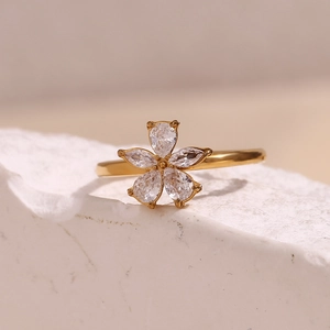 Detailed view of an 18K gold plated flower ring with micro-set zircon on white stone