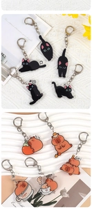 Close-up of cute acrylic cartoon cat and capybara keychains with metal D-ring clips