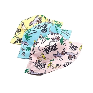 Detail of colorful kids bucket hats featuring cartoon dinosaur prints in yellow, blue and pink