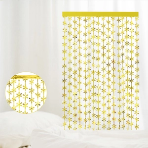 Detail of golden snowflake fringe curtain showing top mounting strap and metallic texture