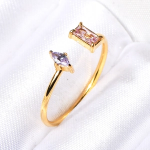 Detailed macro view of the gold-plated open ring with pink and lilac gemstones