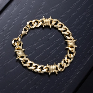 Close-up of golden punk cuban link bracelet with thorn design on black wood background