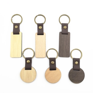Detailed view of assorted rectangular and round wooden keychains with leather straps