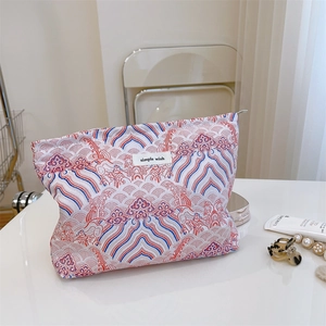 Detailed close-up of a vintage Chinese wave pattern makeup bag on a vanity desk