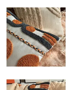 Detailed close-up of bohemian tufted cushion cover with geometric patterns and fringe