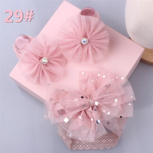 Close-up of baby girl pink lace headband with sequined tulle bow and rhinestone floral clips