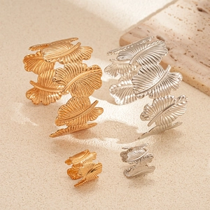 Two-piece gold and silver leaf textured open cuff bracelets and matching rings set