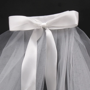 Close-up of white satin bow bridal veil with lightweight mesh texture on black background