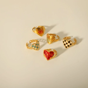 Five gold heart rings featuring colorful enamel patterns and adjustable open bands