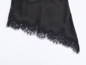 Detailaufnahme von schwarzem Satinstoff mit zarter Wimpernspitze und feinen Nähten