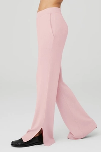 Dettaglio di pantaloni yoga rosa in maglia con elegante spacco laterale sulla caviglia
